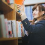 図書室で本を手にする学生の写真